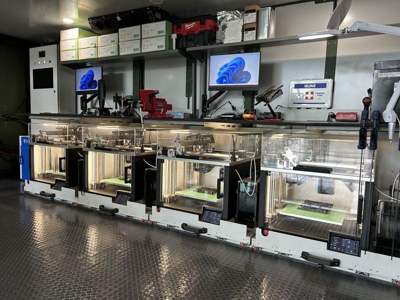 Row of 3D printers and monitors inside a ForgeX unit