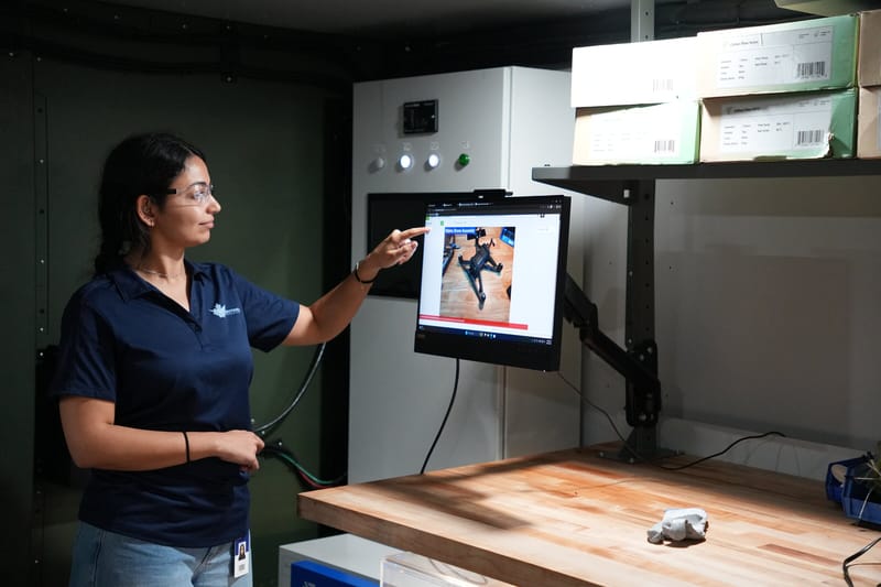 Sentinel employee at a workstation pointing at a monitor