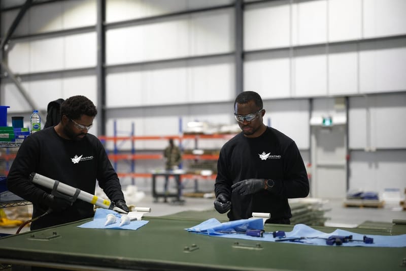 Two technicians assembling unmanned aircraft components at a bench