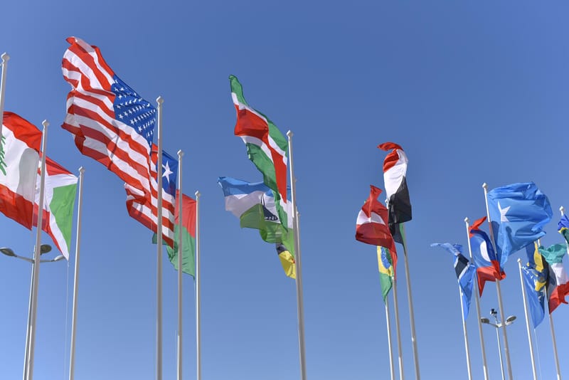 Flags of allied nations flying in a row against a blue sky