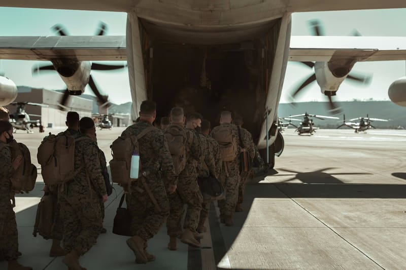 Soldiers boarding a transport aircraft from the rear ramp
